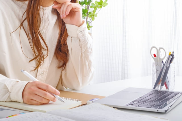 ノートパソコンを見ながら勉強する女性